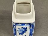 a small blue and white vase with a picture on it