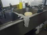 a sink in a kitchen with a lot of clutter on the counter