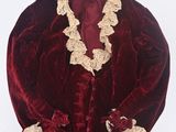 an image of a red velvet jacket with a lace trim and ruffled collar