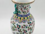 a vase with a bird on it sitting on a table