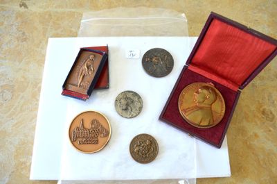une petite boîte contenant des pièces de monnaie et une médaille, posée sur une table