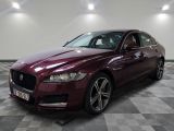 un Jaguar bordeaux garé dans une pièce au sol en damier