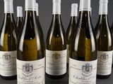 six bottles of wine are lined up in a row on a table