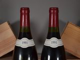 two bottles of wine sitting on a wooden box