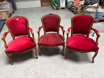 three red chairs in a room with boxes and boxes in the background