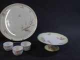 a plate, cups and saucer sitting on a table
