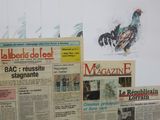 several newspapers are stacked on top of each other on a table