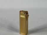 un briquet doré posé sur une surface blanche