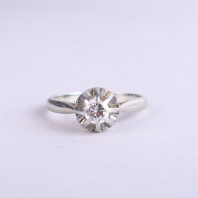 a close up of a diamond ring on a white surface