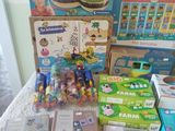 a lot of children ' s toys and books on the bed