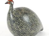 un petit oiseau perché sur une surface blanche