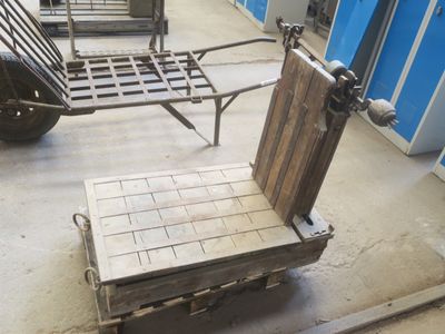 une petite charrette avec un siège en bois dans un garage