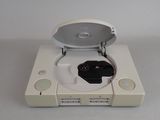 a nintendo wii game console with a controller on top of it