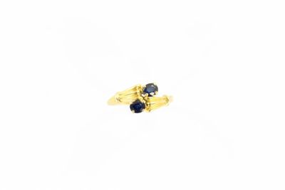 gros plan d'une bague en or avec une pierre en saphir