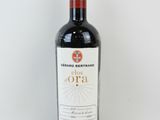la bouteille de vin rouge est posée sur une surface blanche