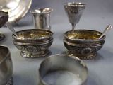 many silver bowls and spoons sitting on a table