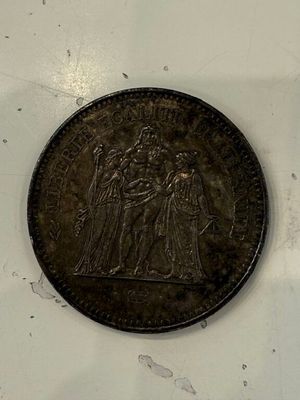 une pièce de monnaie posée sur une surface blanche