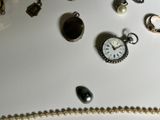 many different types of jewelry on a white table