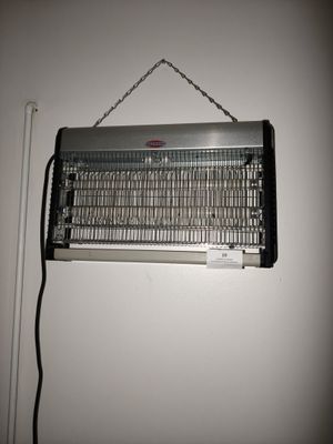 un radiateur métallique accroché au mur, à côté d'un mur blanc
