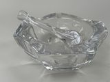 a glass bowl with a spoon in it on a table