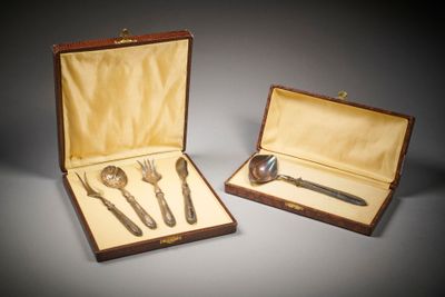 une paire de couverts dans un coffret en bois posé sur une surface grise