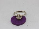 a close up of a diamond ring on a purple surface