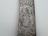 a silver knife that has a design on it