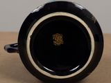 a close up of a black and white cup on a table