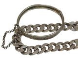 two metal bracelets and a chain on a white background