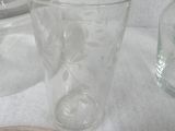 a clear glass cup sitting on a table next to a plate