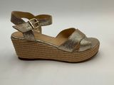 a pair of women ' s gold sandals on a white background