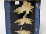 a blue and black vase with a bird design on it