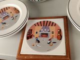 three plates on the table with pictures of people on them