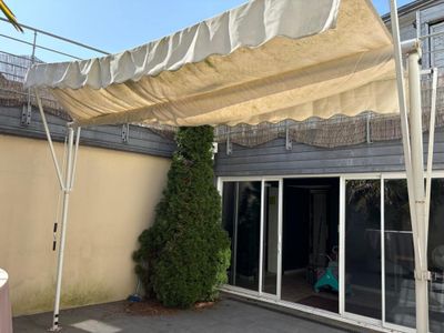 a white awning over a patio area with a table and chairs