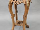 an image of a wooden table with a carved top on a grey background