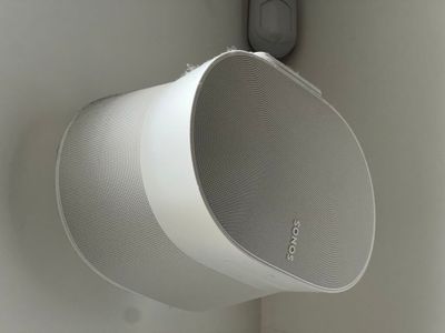 une enceinte blanche accrochée au mur à côté d'une porte