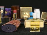 many bottles of perfume sitting on a black surface