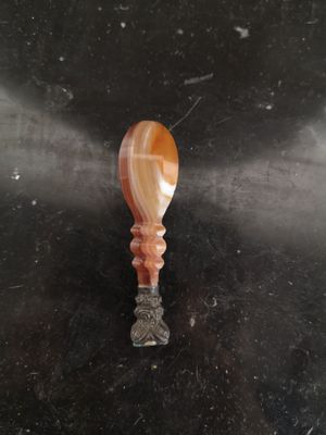 une cuillère orange et blanche posée sur une table noire