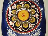 a blue plate with a yellow flower on it