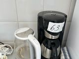 a coffee maker on the counter next to a cup of coffee