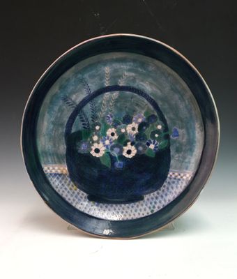 a blue plate with a basket of flowers on it