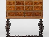 une vieille commode en bois ornée de sculptures élaborées sur le dessus