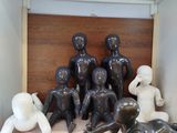 de nombreux mannequins assis sur une table dans une pièce