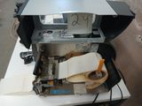a printer sitting on top of a table with a roll of tape on it