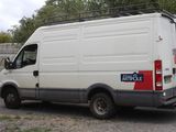 a white van parked in a parking lot with trees in the background
