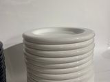 a stack of white plates sitting on a table