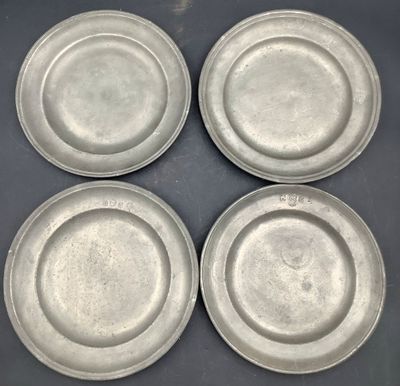quatre assiettes en argent posées les unes à côté des autres sur une table