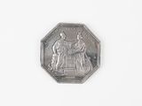 une pièce d'argent sur laquelle figurent les portraits d'un homme et d'une femme
