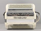 an old white accordion sitting on top of a table next to a gray wall