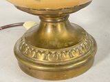 a gold lamp that is sitting on a white table